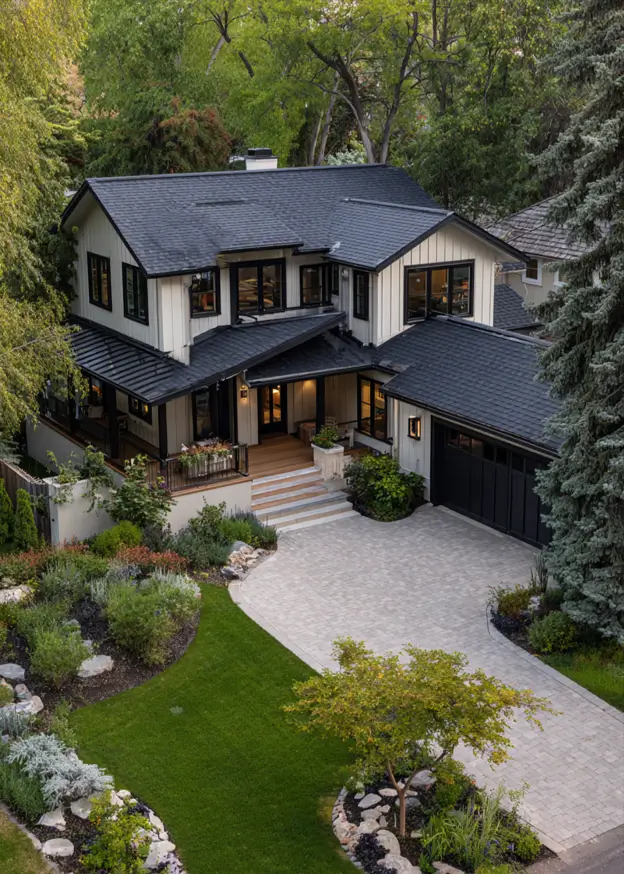 An elevated view of a large black and cream house exterior with a paver driveway and lush landscaping, showing a cohesive design.