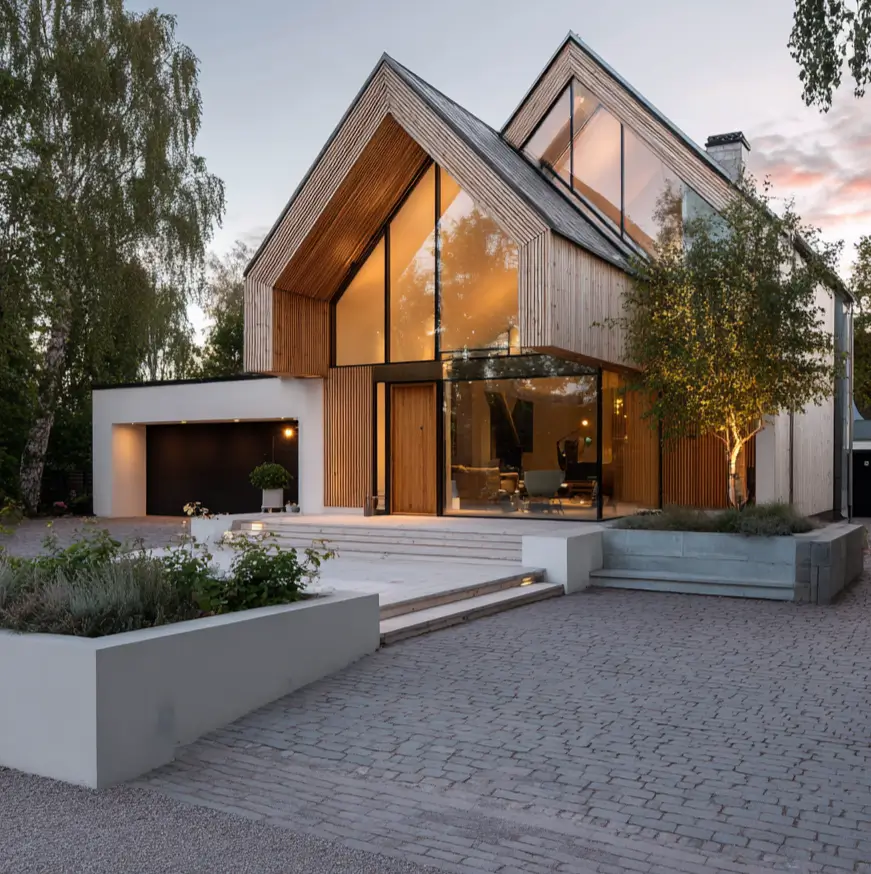 A modern Scandinavian exterior at dusk, featuring a dynamic roofline with multiple gables, light wood cladding, and a curved glass entrance.
