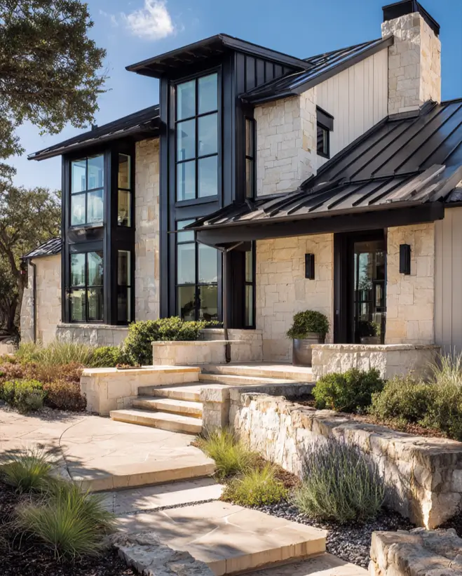 Modern home featuring light stone walls and a contrasting black metal roof, with a prominent glass tower.