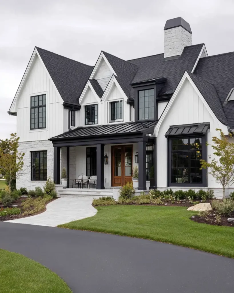 A white and black modern farmhouse with multiple gables and light stone veneer on the lower level.