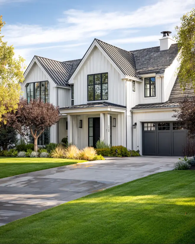 A sleek modern farmhouse exterior idea featuring white vertical siding, a dark gray garage door, and a durable, contemporary standing seam metal roof.