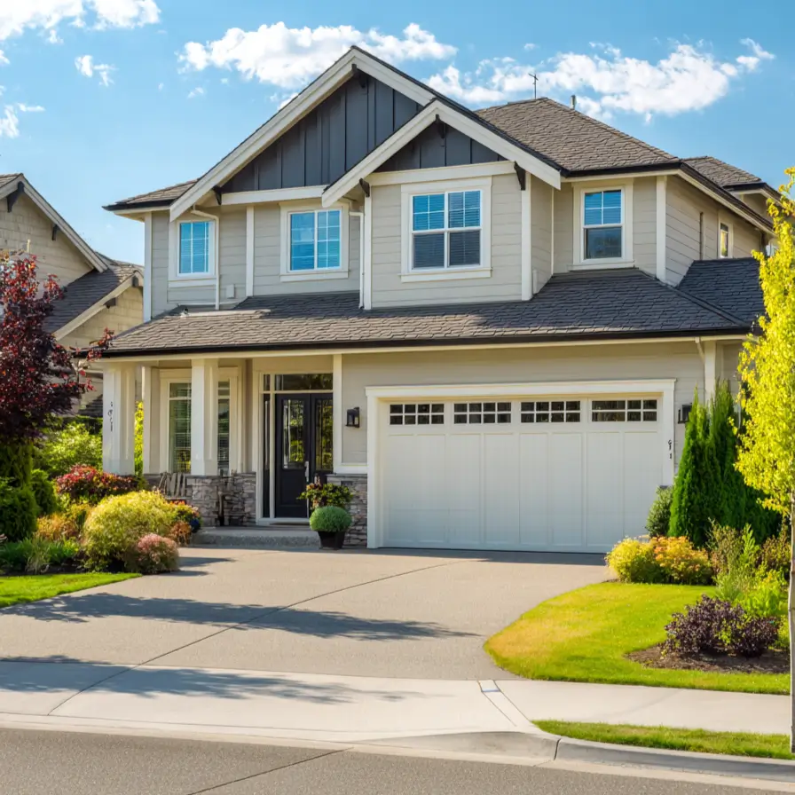 A modern craftsman cream and black house exterior with bright cream siding, black gables, and a white garage door, set against a blue sky.