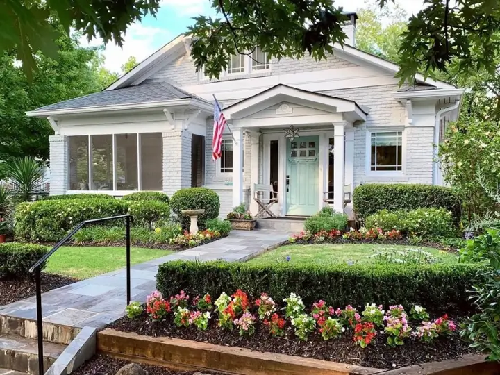 36 Modern Cottage Exterior Ideas to Achieve Timeless Curb Appeal 3 A modern cottage style exterior with light gray painted brick, a welcoming aqua front door, and a manicured garden with a stone walkway.