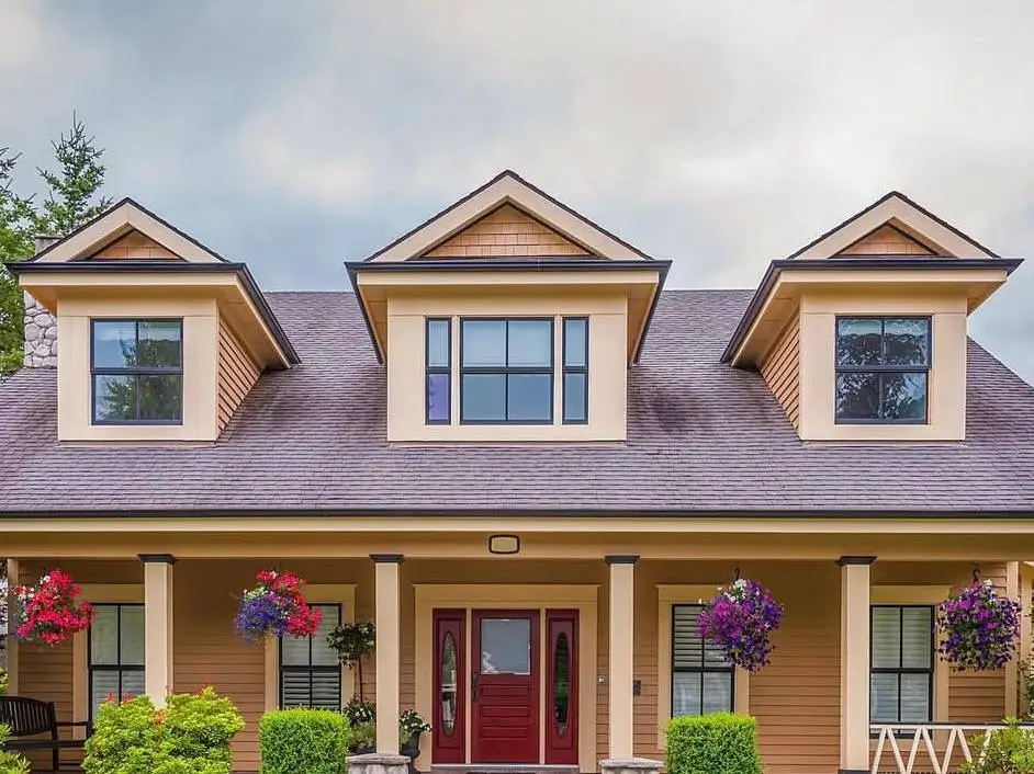 Cost of Installing Dormer Windows: Complete US Pricing Guide 2025 3 A tan craftsman-style home with three classic gable dormer windows on the upper story.