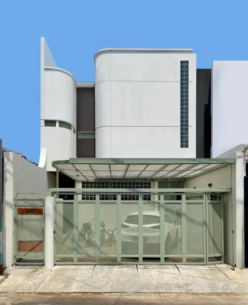 Exterior of a modern minimalist house in Jakarta with Art Deco-inspired curves, designed by SAKA Studio.