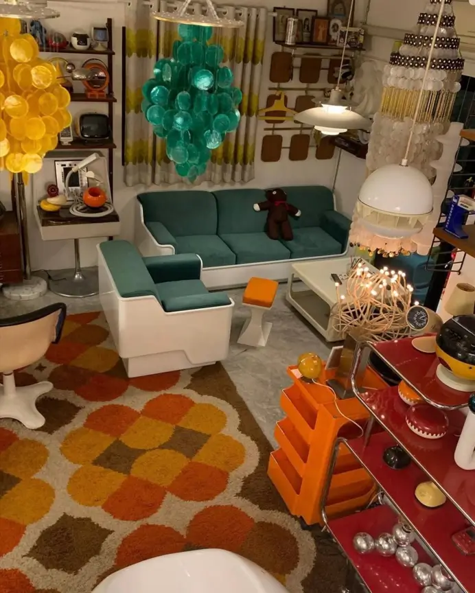 A room with 70s interior decor, featuring a large patterned rug in orange and brown and white plastic seating.