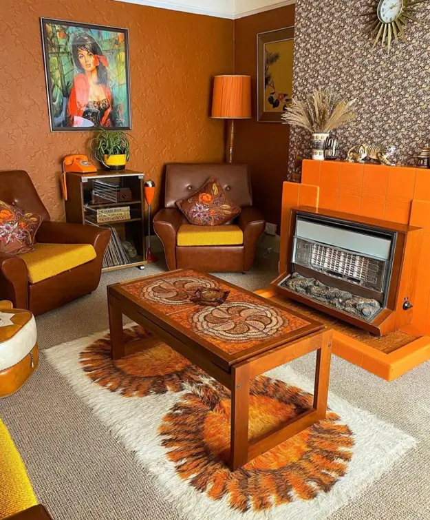 A 70s living room with brown leather chairs, an orange fireplace, and a patterned rug.