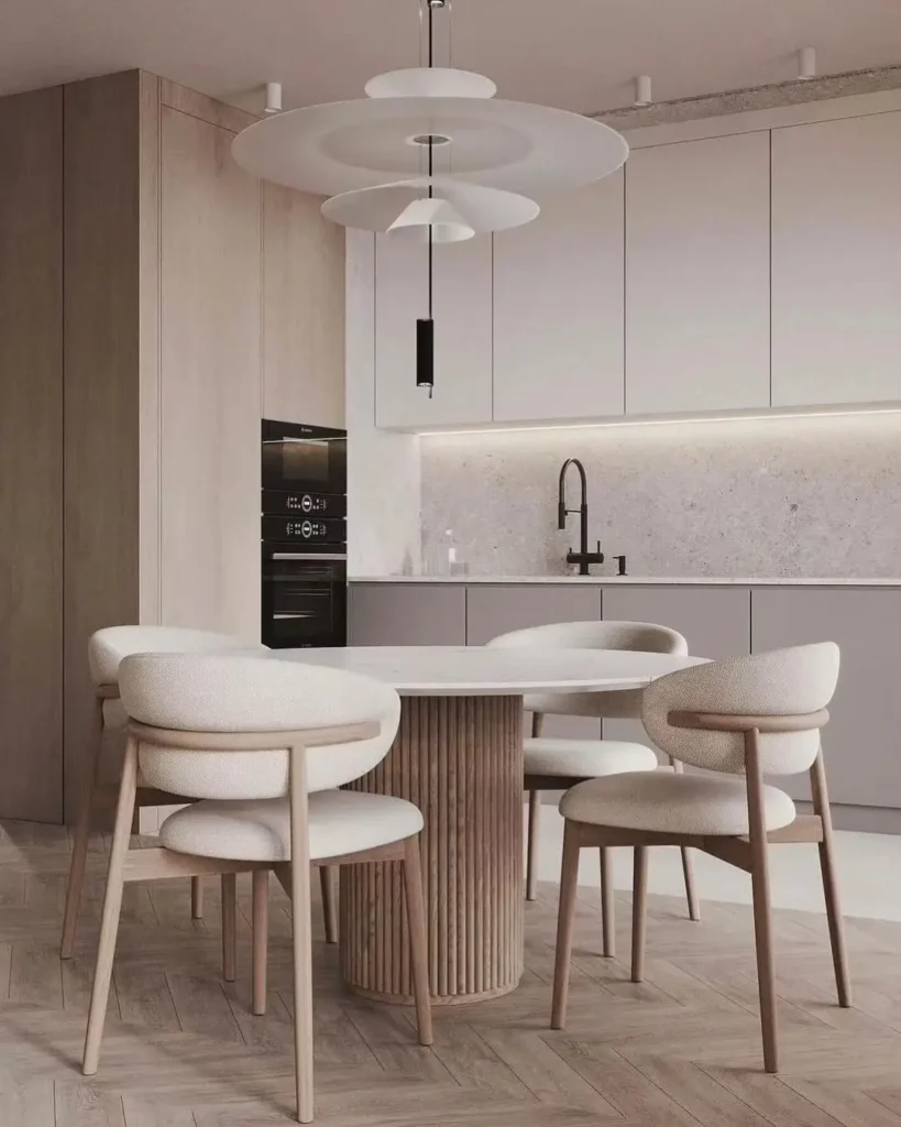 A serene dining area with a reeded wood condo dining table and tactile bouclé chairs in a modern, minimalist kitchen.