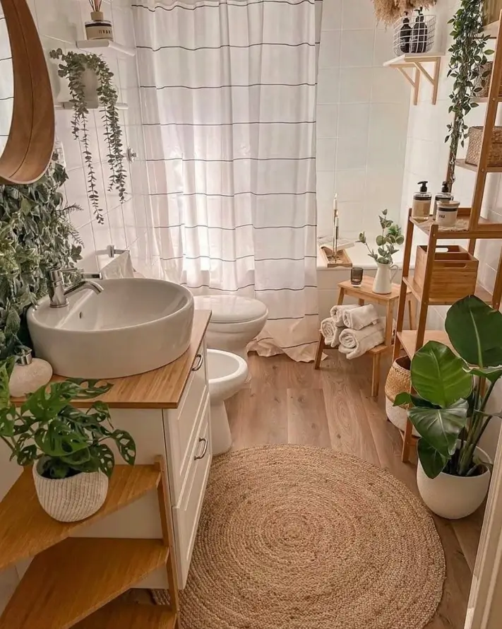 A cozy small apartment bathroom with a jute rug, wooden accents, and many plants creating a natural interior design.