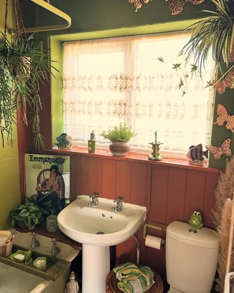 A retro 70s bathroom with terracotta-colored wood paneling, green walls, and an abundance of houseplants.