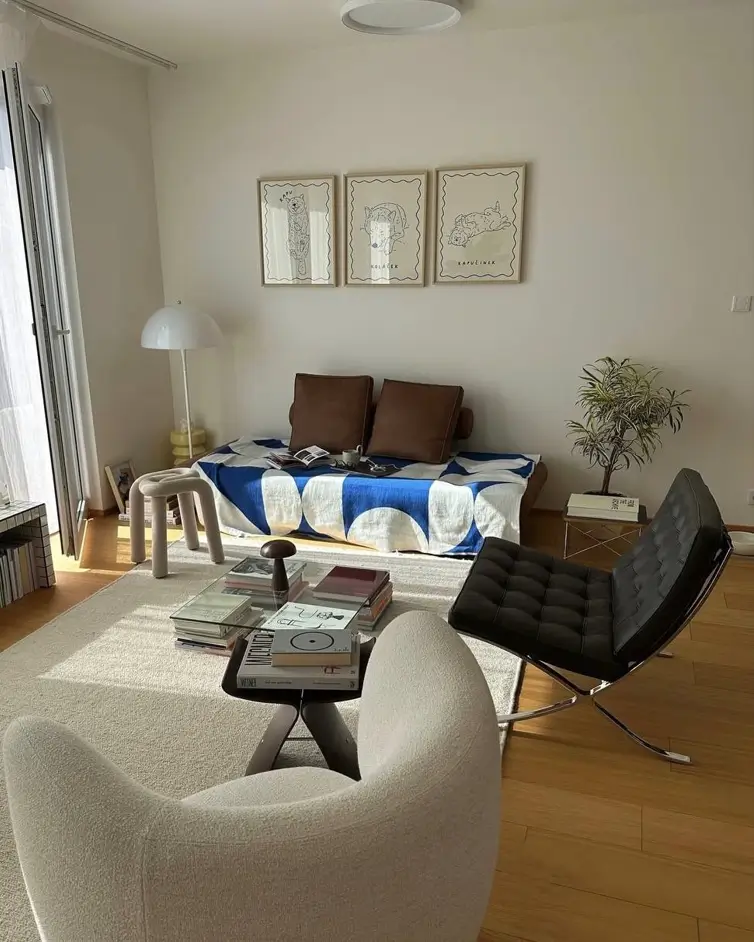 A sunlit, cozy small apartment living room where a coffee table styled with books serves as the focal point for the interior design.
