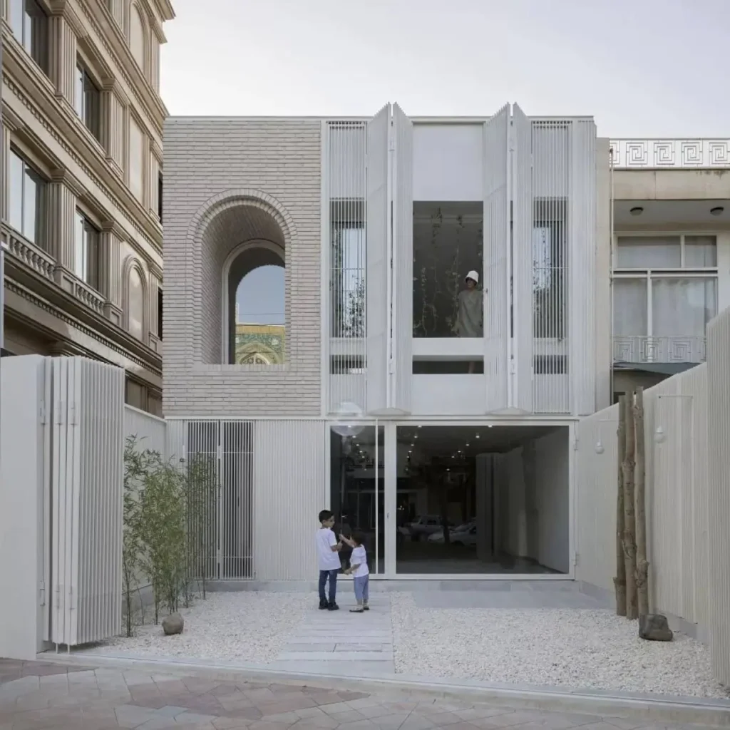 Modern minimalist house with a textured brick and white louvered facade featuring a prominent arched window.