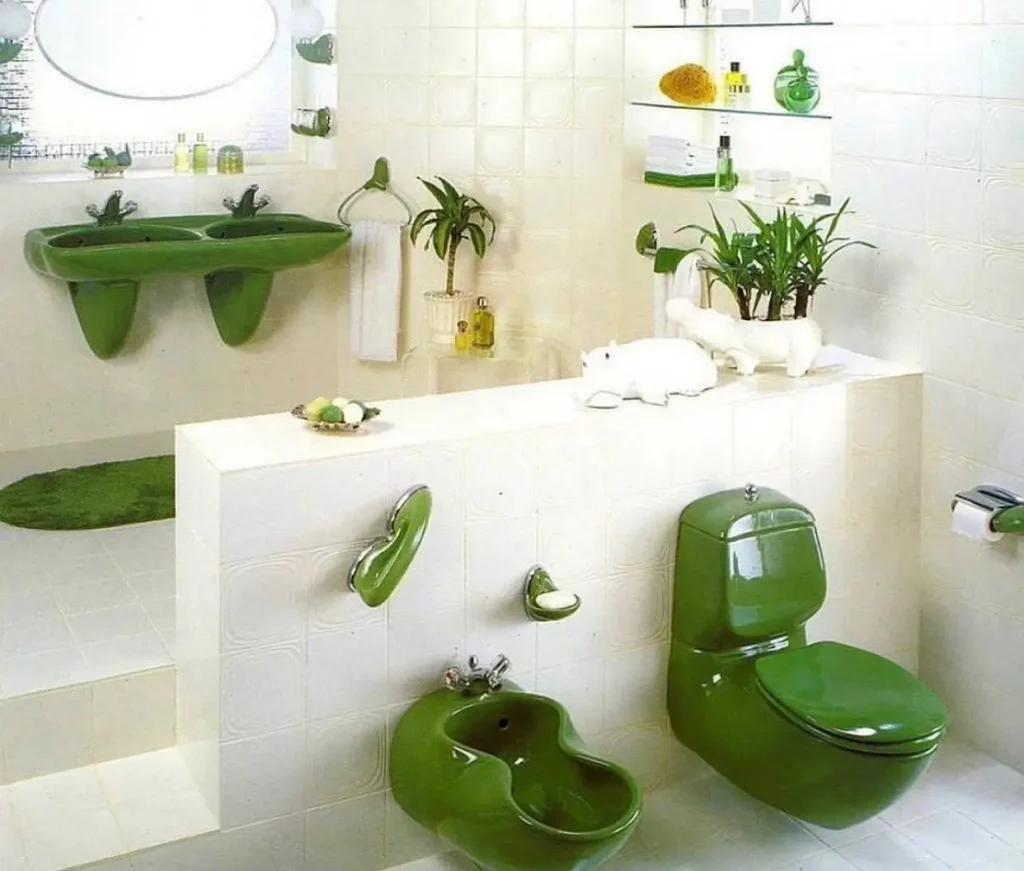 A retro 70s bathroom featuring matching avocado green fixtures, including a toilet, bidet, and double sink.