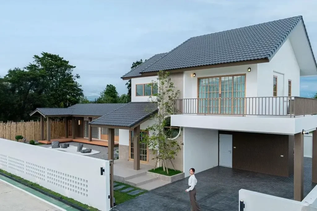 A modern Japanese style house with a white facade and a separate wing with an engawa porch and dry garden.