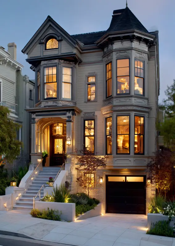 A modern Victorian style home at dusk with warm exterior lighting highlighting its architecture.