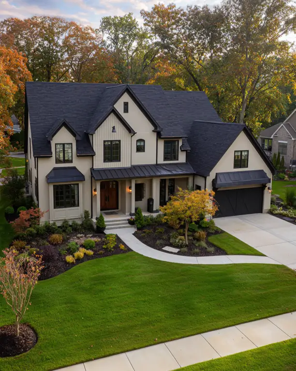 An aerial view of a beige and black modern farmhouse with mixed siding and a curved walkway.