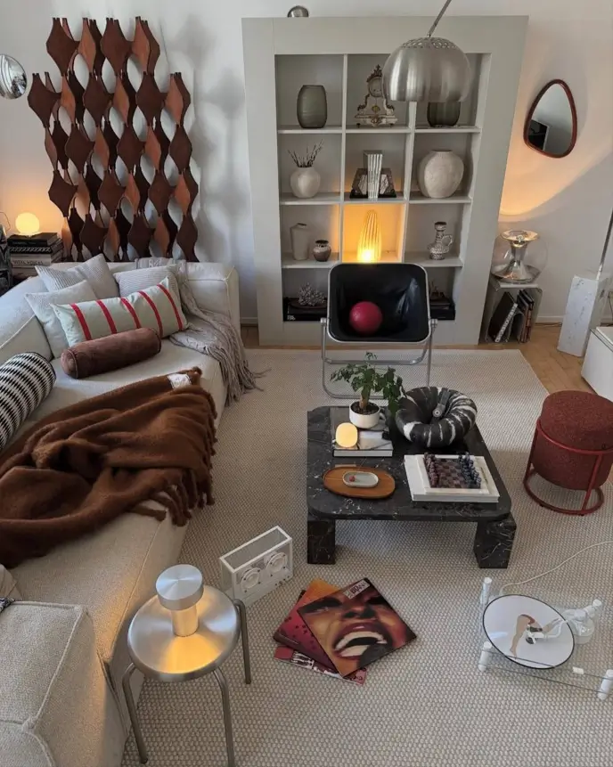 A modern, cozy small apartment living room with styled built-in shelves, a textured sofa, and a curated marble coffee table.