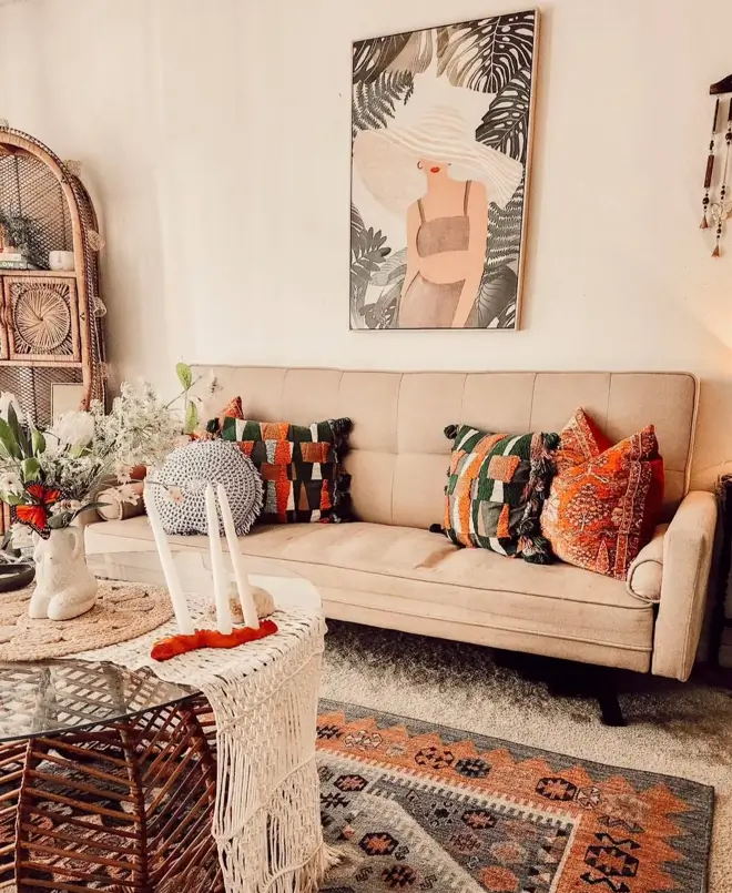 A boho 70s living room with a beige sofa, rattan shelving, and a macrame coffee table.