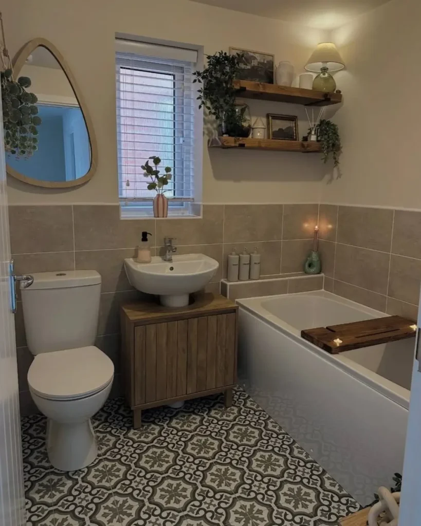 A cozy small apartment bathroom with patterned floor tiles, a wooden vanity, and soft lighting creating a spa-like interior.