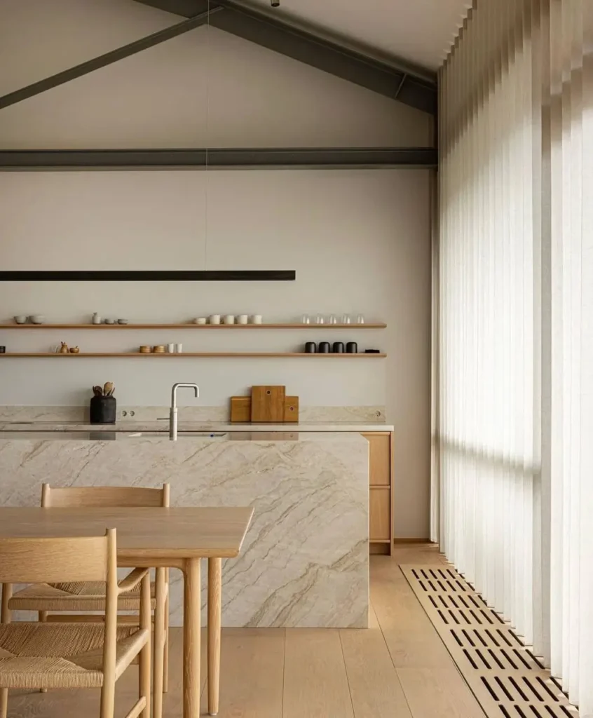 A custom oak and stone kitchen island by Norm Architects inside the industrial Holmen Abode.