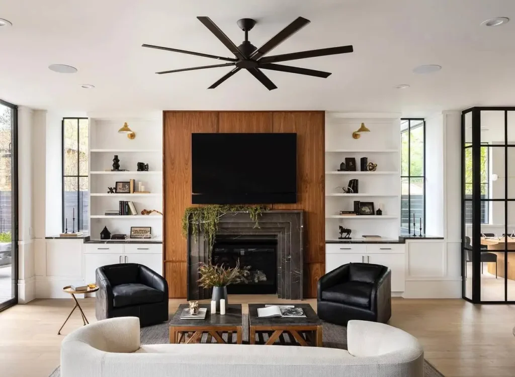 A modern Victorian living room with a classic marble fireplace, wood paneling, and contemporary furniture.