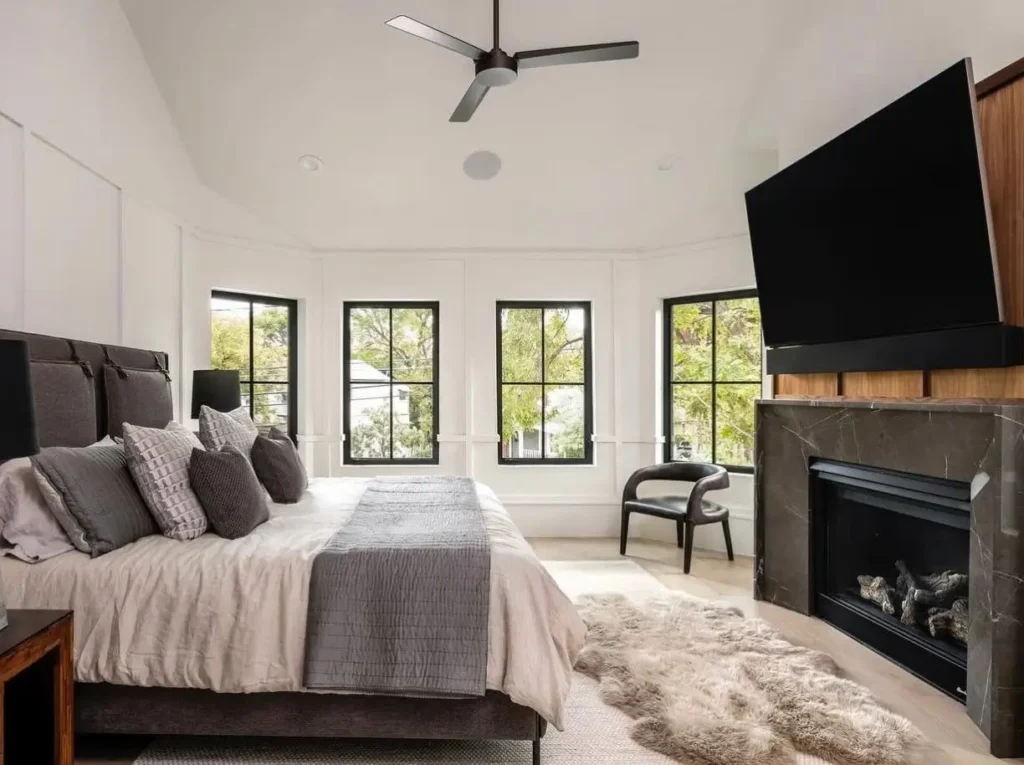 A modern Victorian bedroom interior with a minimalist design, neutral palette, and a large bay window.