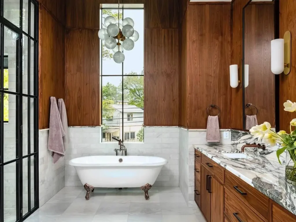 A luxurious modern Victorian bathroom with rich wood paneling, marble tiles, and a classic clawfoot tub.