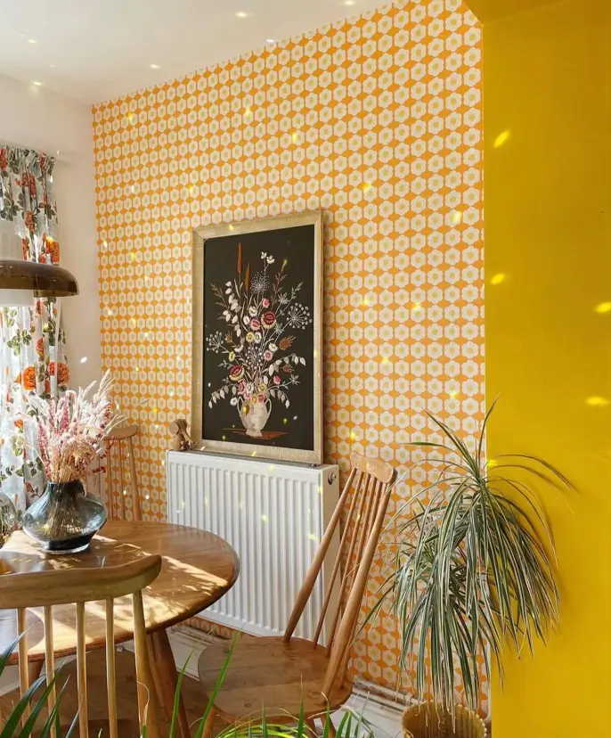 A dining nook showing 70s interior design ideas with bright geometric wallpaper and simple wooden chairs.