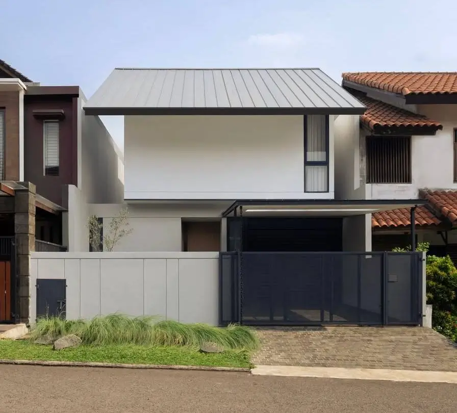 Modern minimalist gabled house in Jakarta by J O D A, featuring a high-contrast three-tone facade.
