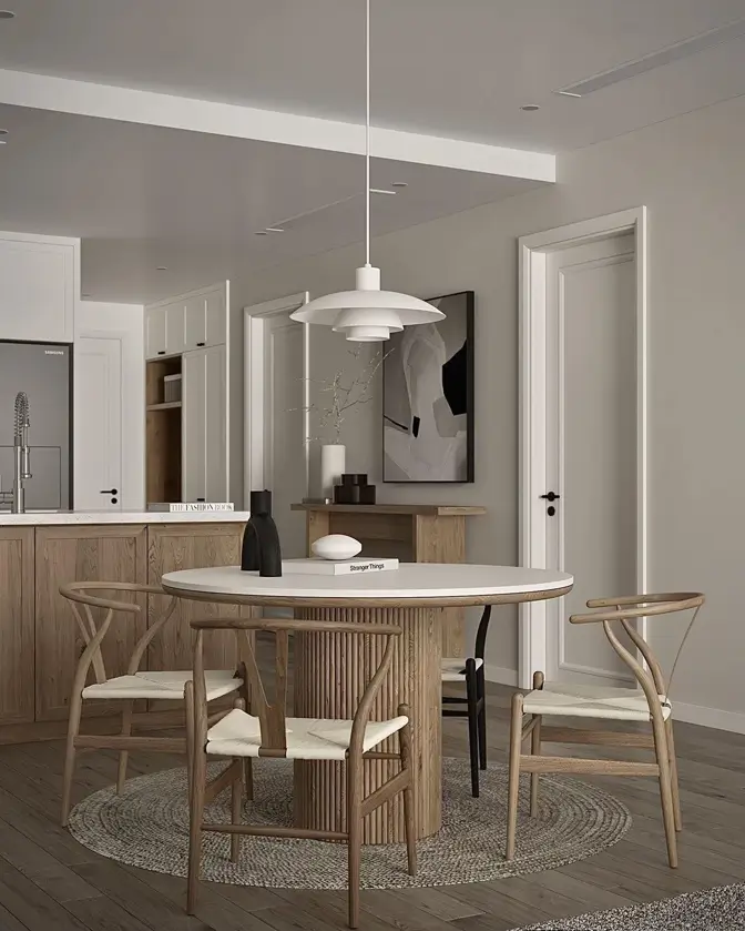 An open-concept condo dining area with a light wood table and wishbone chairs that match the adjacent modern kitchen.