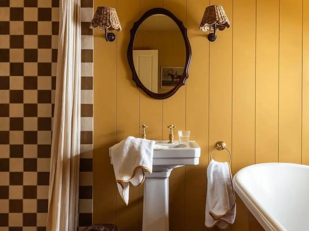 23 Ways to Embrace 70s Bathroom Decor for a Modern Revival 2 A modern 70s bathroom with gold wood paneling and checkerboard tile, showcasing 70s bathroom decor ideas for a modern revival.