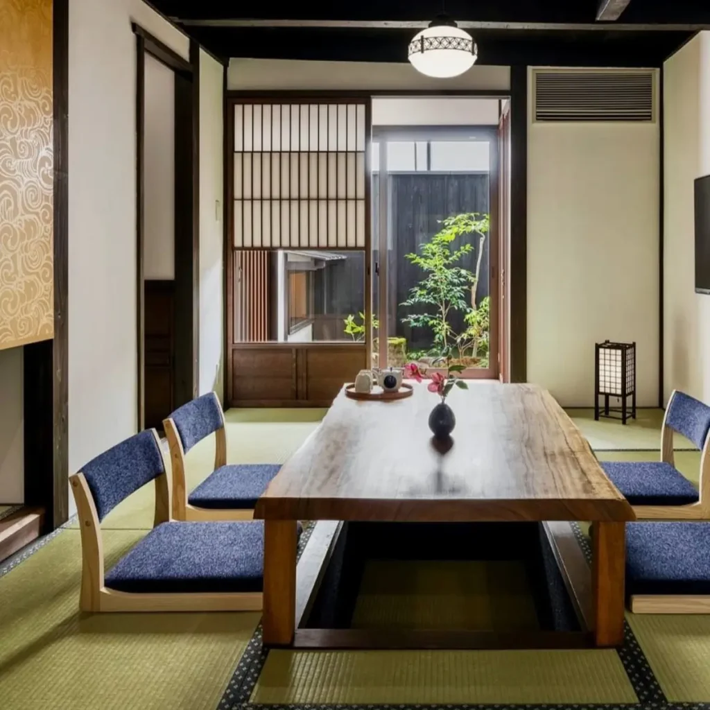 Traditional Japanese living room idea featuring a sunken horigotatsu table, tatami mats, and garden view.