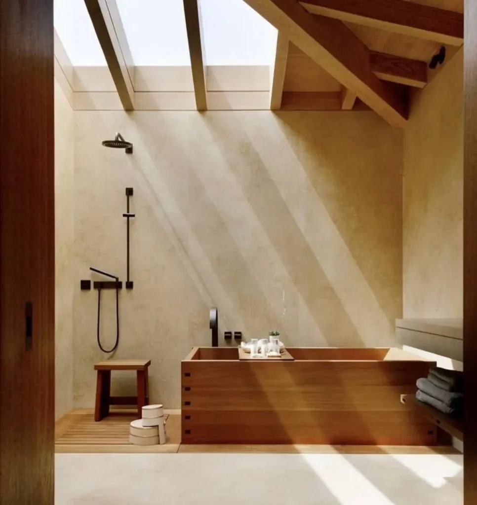 26 Japanese Bathroom Design Ideas for a Serene Home Oasis 15 A Japanese bathroom with plaster walls, a wooden tub, and a skylight casting light.