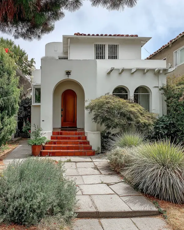 38 Small Mediterranean-Style Homes That Define Coastal Charm 15 Sculptural white small Mediterranean house design with a simple curved facade and exposed terracotta step risers.