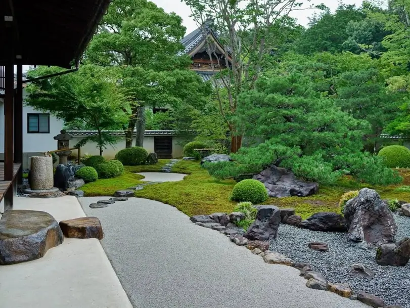Japanese zen garden design using borrowed scenery to include distant trees and a temple.