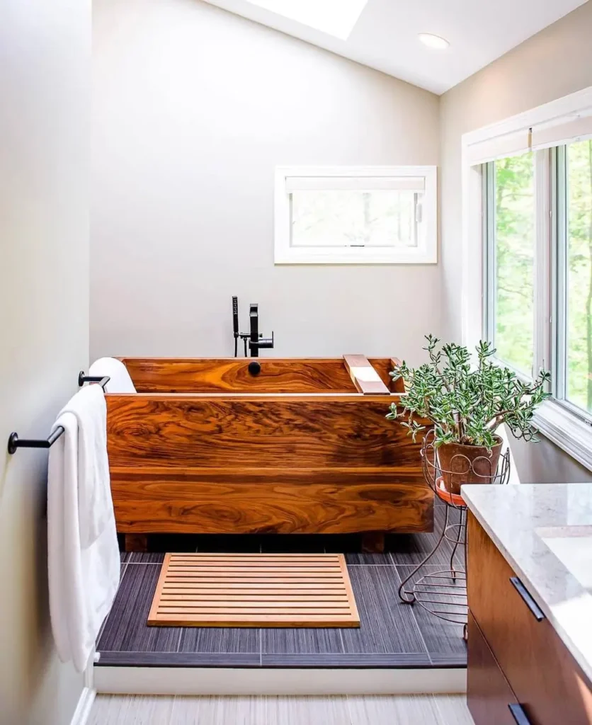 26 Japanese Bathroom Design Ideas for a Serene Home Oasis 19 A Japanese inspired bathroom with a large, dark-grain wooden ofuro-style tub and dark tile floors.