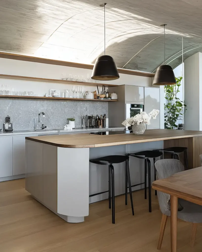 Contemporary Scandinavian kitchen featuring curved concrete ceiling and large oak island.