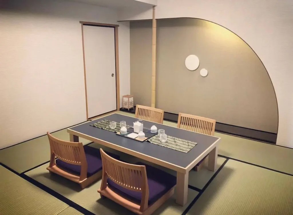 Traditional Japanese tatami room with zaisu chairs, a low table, and a decorative alcove.