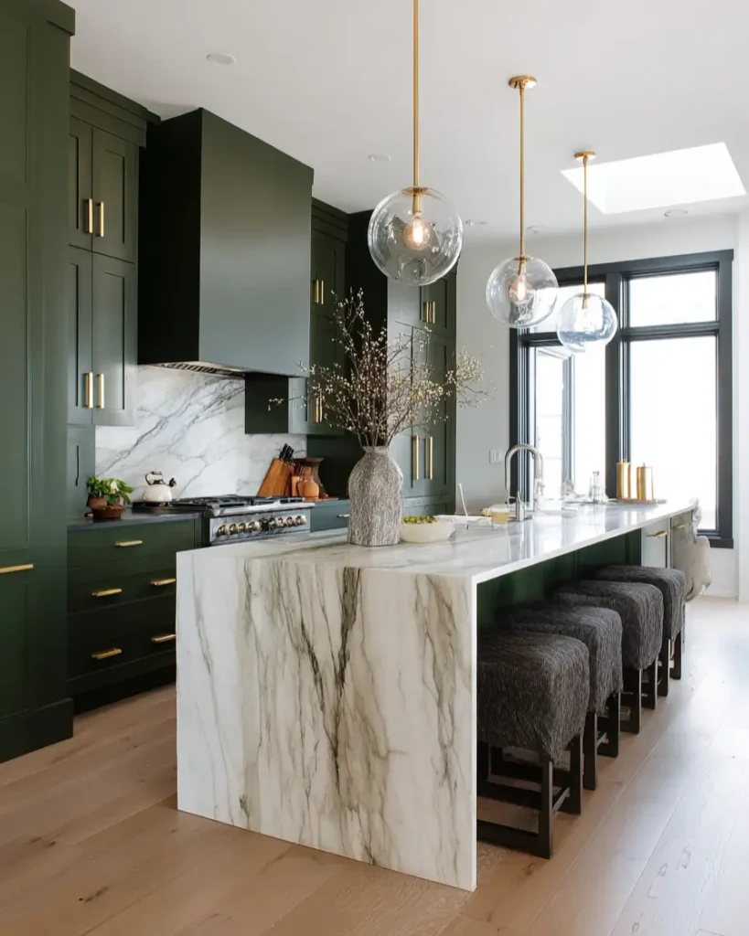 Modern kitchen featuring deep olive green cabinets, a matching range hood, and elegant brushed gold hardware.