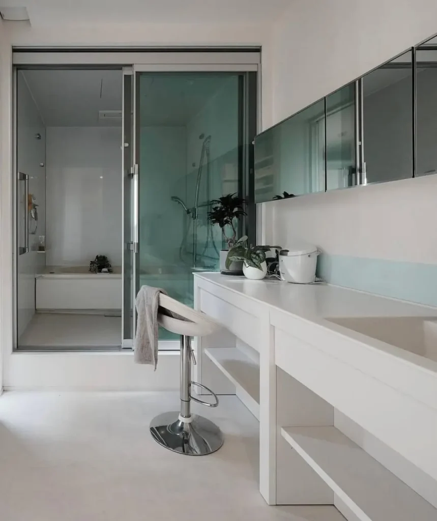 26 Japanese Bathroom Design Ideas for a Serene Home Oasis 21 A small Japanese bathroom with a white vanity and a separate glass-enclosed wet room.