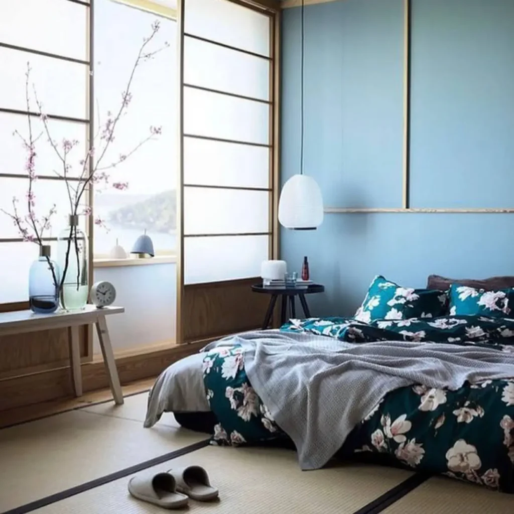 A Japanese bedroom with tatami mats, shoji screen windows diffusing soft light, and a low bed.