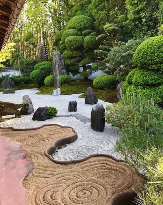 Japanese zen garden with dual-tone sand raked in water patterns and sculpted pines.