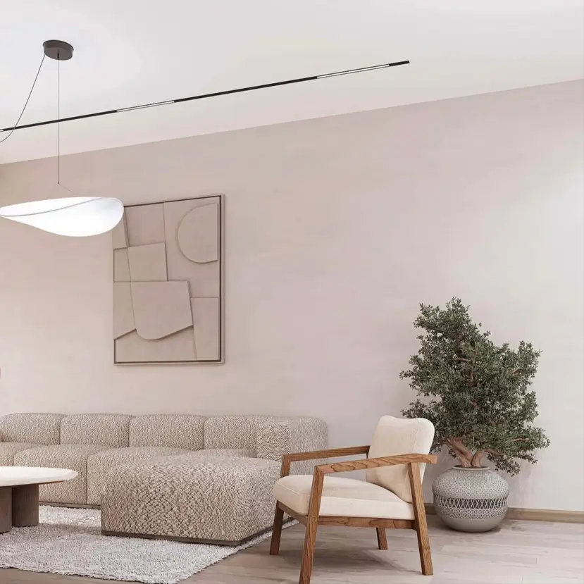 Neutral minimalist Japandi living room with a textured sofa, wood-framed chair, and abstract wall art.