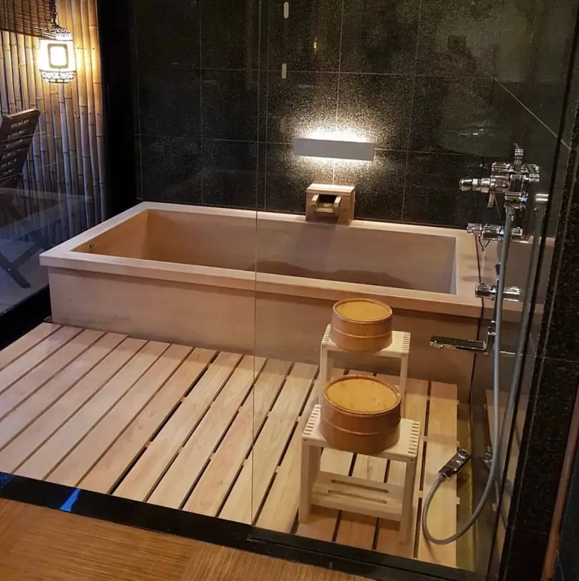 26 Japanese Bathroom Design Ideas for a Serene Home Oasis 23 A Japanese wet room with a wooden ofuro, slatted floor, and dark tile walls, enclosed in glass.