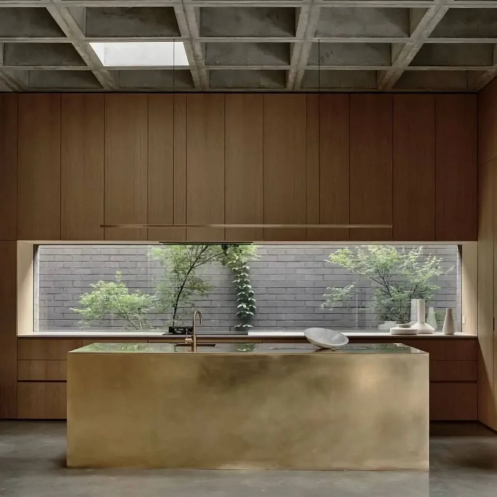 A Japanese inspired kitchen with dark wood cabinets, a concrete ceiling, and a long window viewing a garden.