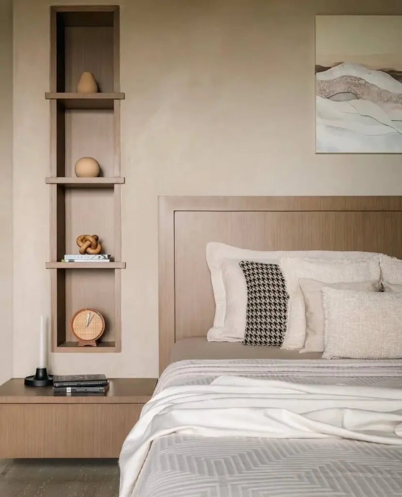 A Japandi bedroom with a light wood headboard and a matching built-in vertical wall niche for display.