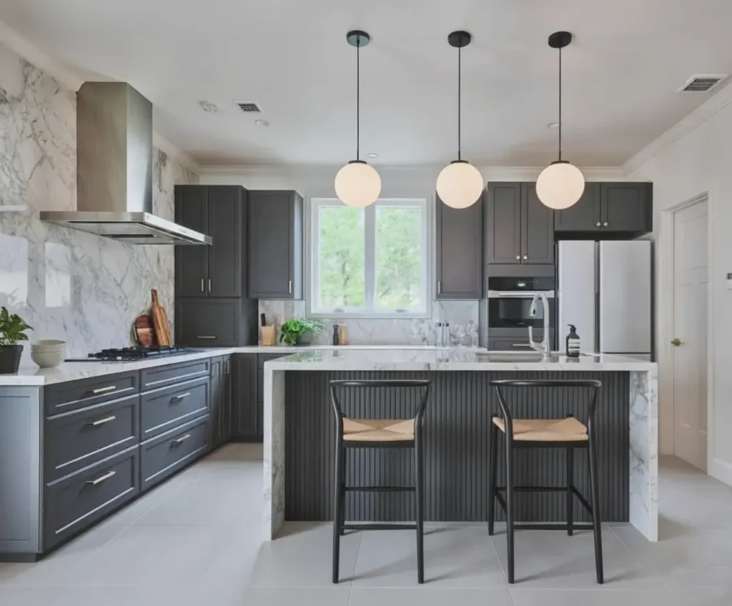 A Japanese inspired kitchen blending dark shaker cabinets, a fluted island, and a marble backsplash.