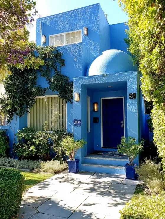 38 Small Mediterranean-Style Homes That Define Coastal Charm 26 Bold cobalt blue small Mediterranean home with textured stucco walls, a recessed entryway, and a domed roof feature.