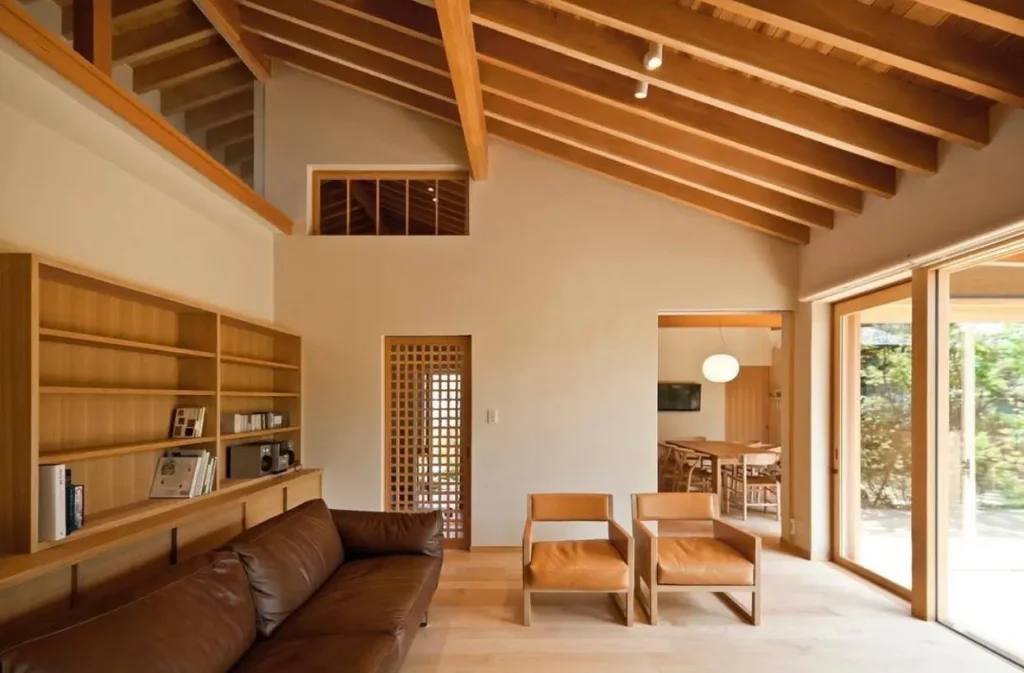 Spacious Japanese style living room with a high vaulted wood ceiling, leather sofa, and built-in shelving.