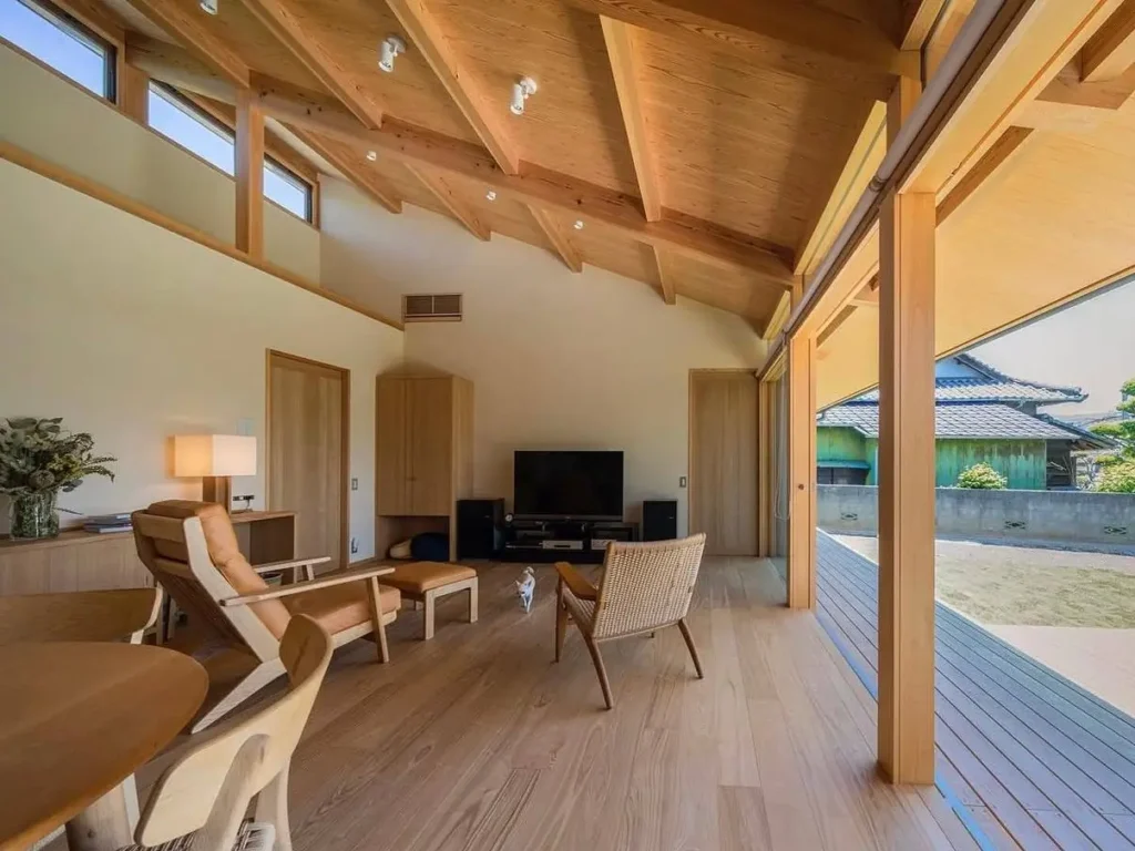 Open-plan living room with a vaulted wood ceiling opening onto a large covered veranda.